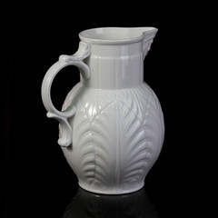 Fototapeta na wymiar antique white porcelain vase in on a black isolated background. antique ceramic vase with stucco