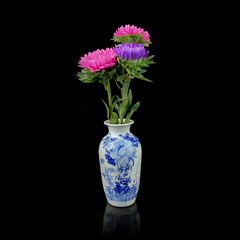 antique vase in oriental style with a bouquet of peonies on a black isolated background. vintage vase with flower pattern