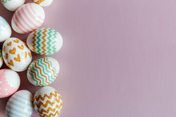 Easter eggs in pastel colors with a pattern on a pink background.