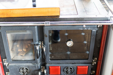 black metal stove fireplace with a burning flame behind a glass door in the interior
