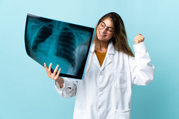 Professional traumatologist isolated on blue background celebrating a victory