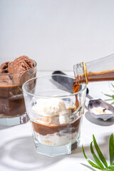 Summer cold cocktail. Amaro floats with chocolate and vanilla ice cream. Affogato Coffee latte with ice cream drink. Copy space on a white table