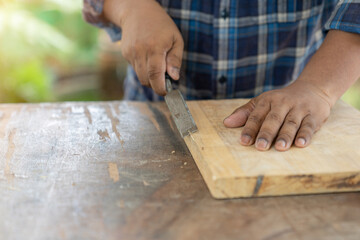 Cropped view of woodworker holding chisel wood.