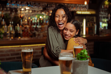 Female friends hugging each other in restaurant