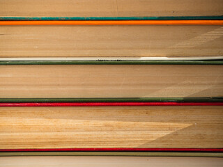A stack of hardcover Books. Old, battered and faded hardcover books or textbooks in a bookstore or library.  The concept of "Back to School and Education" is a look at colorful hardcover books