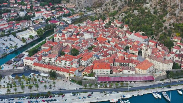 Cathedral Saint Tryphon is Roman Catholic cathedral in old town of Kotor, Montenegro. Lovcen mountain at background. View from drone. Great view of Kotor bay (Boka Kotorska) in sunny day. 
