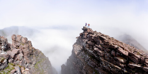 Man and woman standing on mountain cliff