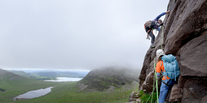 Man and woman climbing together on mountain