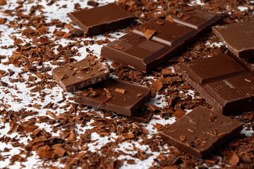 Grated chocolate and pieces of tasty chocolate on table