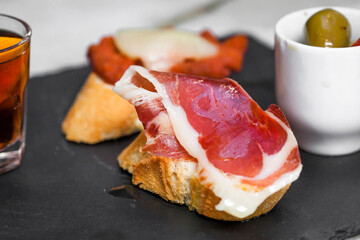 Bruschetta topped with bacon and served with a cocktail 