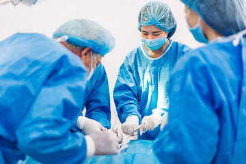 Professional anesthesiologist doctor medical team and assistant preparing patient to gynecological surgery performing operating with surgery equipment in modern hospital operation emergency room