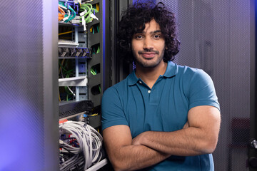 Technician with arms crossed standing in server room