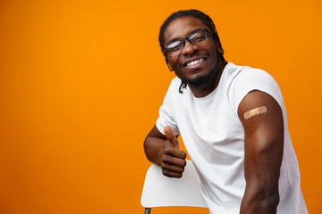 Young black man got vaccinated from coronavirus against yellow background