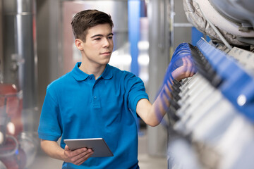 Technician analyzing machine through tablet PC in industry