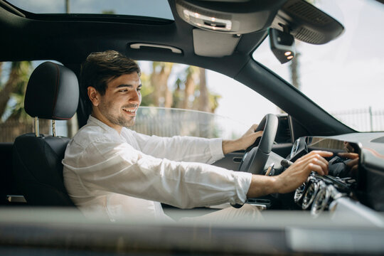 Man operating control panel sitting in electric car