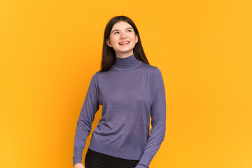 Young Ukrainian girl isolated on yellow background thinking an idea while looking up