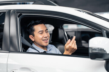 Asian attractive man customer hold remote car key while sit in vehicle. 