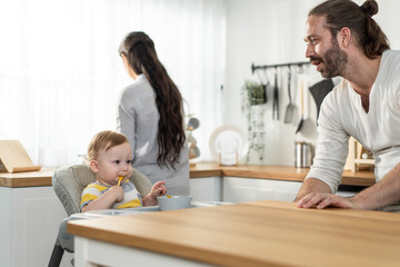 Obraz premium Caucasian young baby toddler eating healthy foods in kitchen at home.