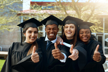 If we can so can you. Portrait of a group of young students showing thumbs up on graduation day.