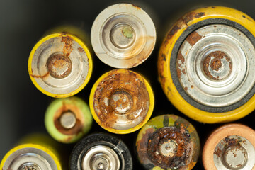 Closeup of used battery with traces of rust and corrosion, selective soft focus. Macro shot of lot...