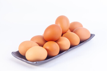 chicken eggs lies in a japaness ceramic saucer on white background.