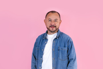 portrait of hispanic senior man wearing casual clothes smiling at camera on pink background in...