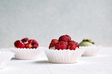 Delicious tartlets dessert assorted pastries. Mini tartlets with cream cheese, pistachio cream filling and strawberries. Closeup of delicious pastry sweets pies.