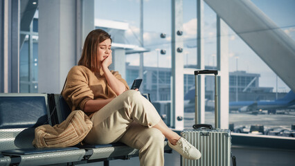 Airport Terminal: Woman Waits for Flight, Uses Smartphone, Receives Bad News, Starts Crying. Upset,...