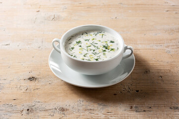 Bulgarian tarator sour milk soup in bowl on wooden table