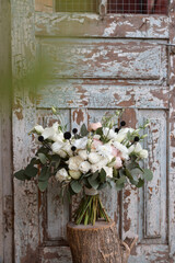 Fototapeta na wymiar Modern bridal bouquet made from roses, freesia, eustoma and eucalyptus on dark background.