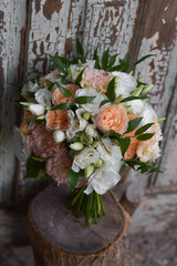 Fototapeta na wymiar Modern bridal bouquet made from roses, freesia, eustoma and eucalyptus on dark background.