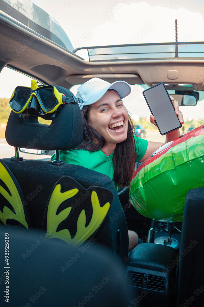 Canvas Prints happy woman in car full of sea vacation stuff holding phone with white screen