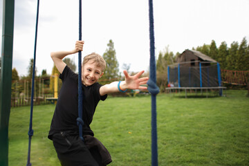 the boy goes through an obstacle course, goes in for active sports, tries to reach the rope