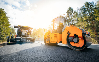 Vibratory asphalt rollers compactor compacting new asphalt pavement. Road service repairs the highway
