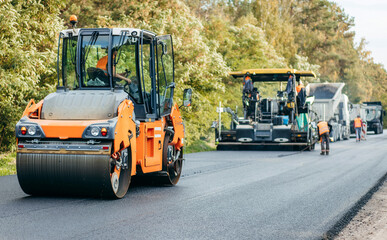 Vibratory asphalt rollers compactor compacting new asphalt pavement. Road service repairs the highway