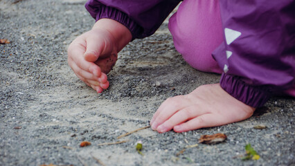Child making a pile of gravel/Enfant faisant un tas de gravier