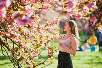 Beautiful girl in cherry blossom garden on a spring day
