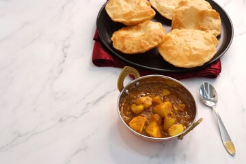 Indian cuisine - Puri Bhaji. It is a traditional breakfast dish in North India. Puri is a deep fried bread made from whole wheat flour and Served with spicy Potato curry called bhaji or alu ki sabji.