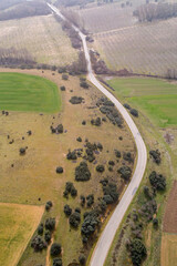 drone aerial view of a road between plowed crop fields