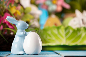 Easter time. Easter decorations on blue painted wooden table. Easter bunny, easter eggs in basket...