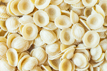 Dry uncooked orecchiette Italian pasta as food background