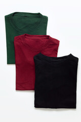 Folded black, dark red and green t-shirt with white background