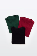 Folded black, dark red and green t-shirt with white background