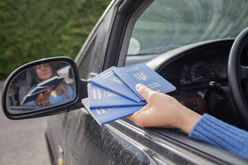 A family of Ukrainian refugees fleeing from the war against Russia. Mother shows passports at the...