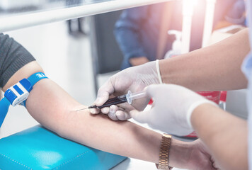 Close up hand of nurse, taking blood sample from a patient in the hospital.