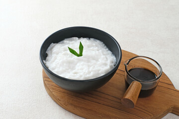 Bubur sumsum made from rice flour and coconut milk is traditional Indonesian porridge. Served with brown sugar syrup. Selected focus.
