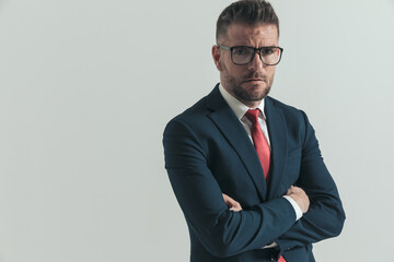 middle aged businessman with glasses crossing arms and posing