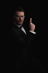 sexy businessman in tuxedo with glasses pointing finger in the air