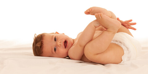 Fototapeta na wymiar Hapy baby boy in playing on bed isolated over white