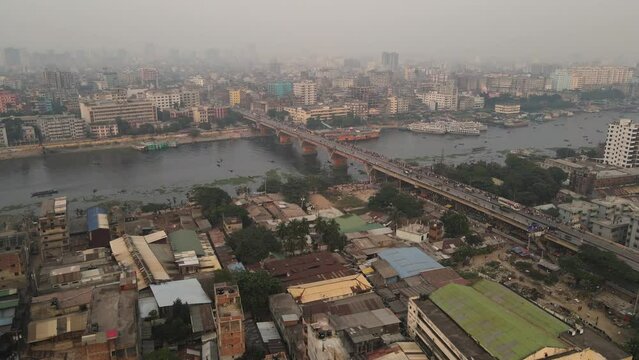 Busy bridge crossing Bangladesh river in a polluted atmosphere. Aerial